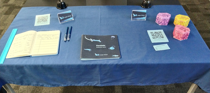 A lengthwise display table with a custom blue tablecloth.